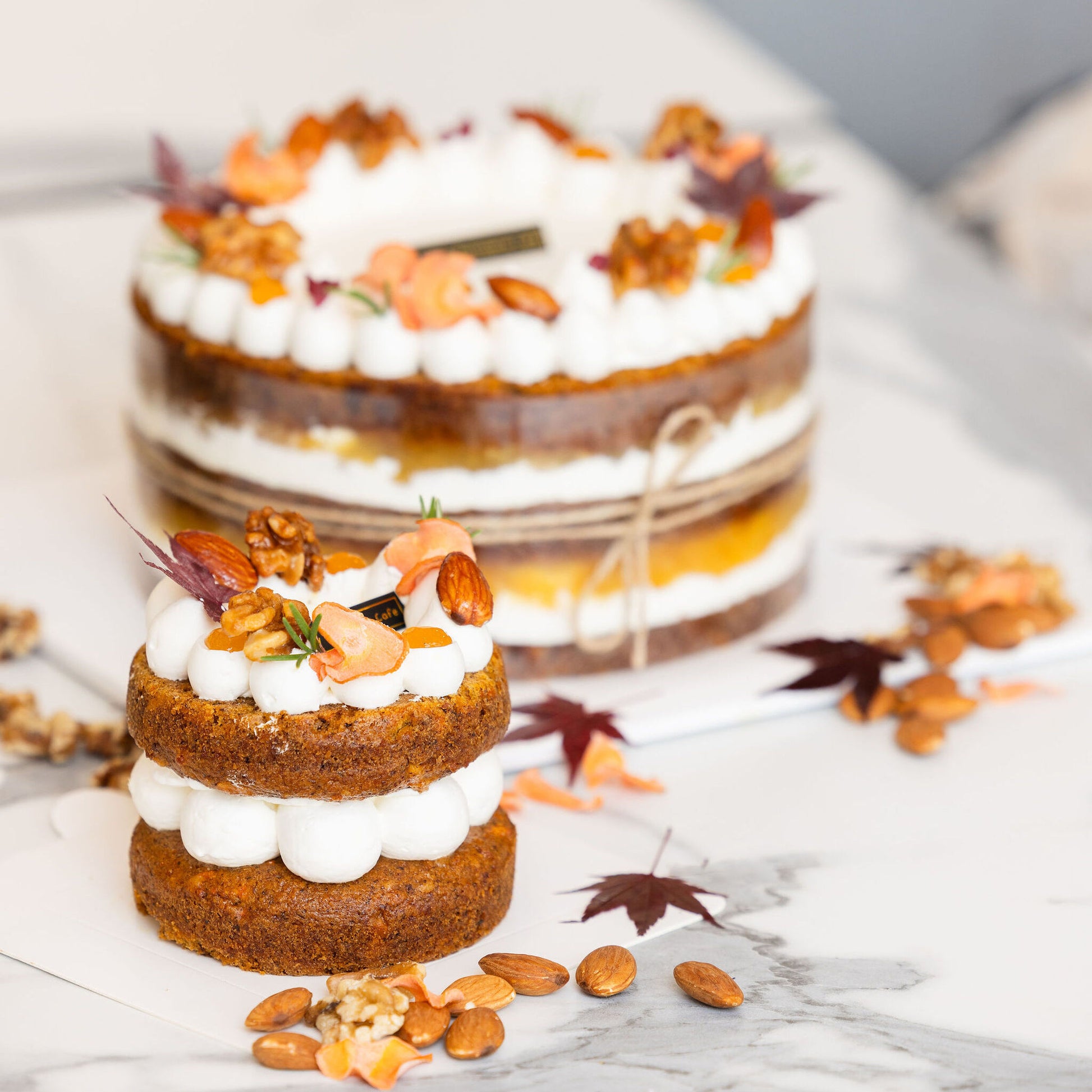 Top detail of vegan carrot shortcake featuring carrot garnish and creamy frosting design.