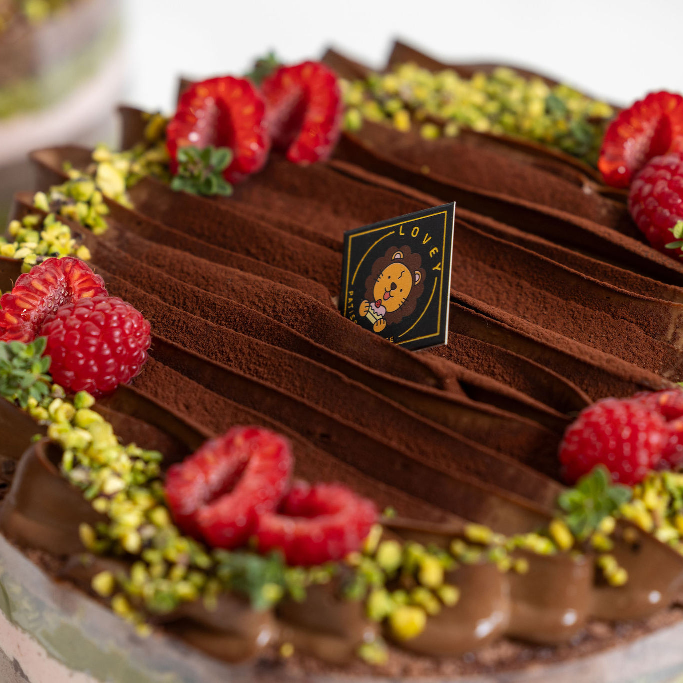 Slice view of Dubai Chocolate Pistachio Shortcake revealing chocolate sponge, pistachio cream and raspberry layers.